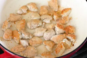 cornstarch coated chicken pieces browned in a pan