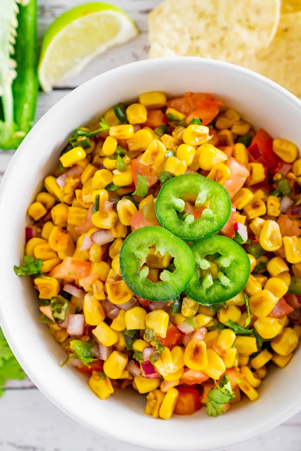 charred corn salsa in a bowl topped with jalapeno garnish