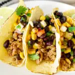 ground pork tacos with pineapple salsa on a plate