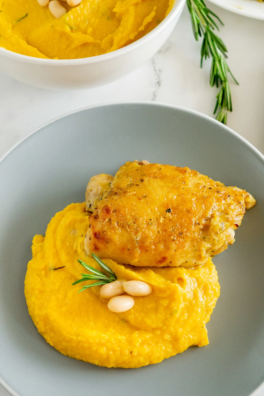 butternut squash mash and white beans on the side of honey roasted chicken thighs