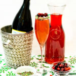 cranberry prosecci drink next to pitcher of cranberry juice
