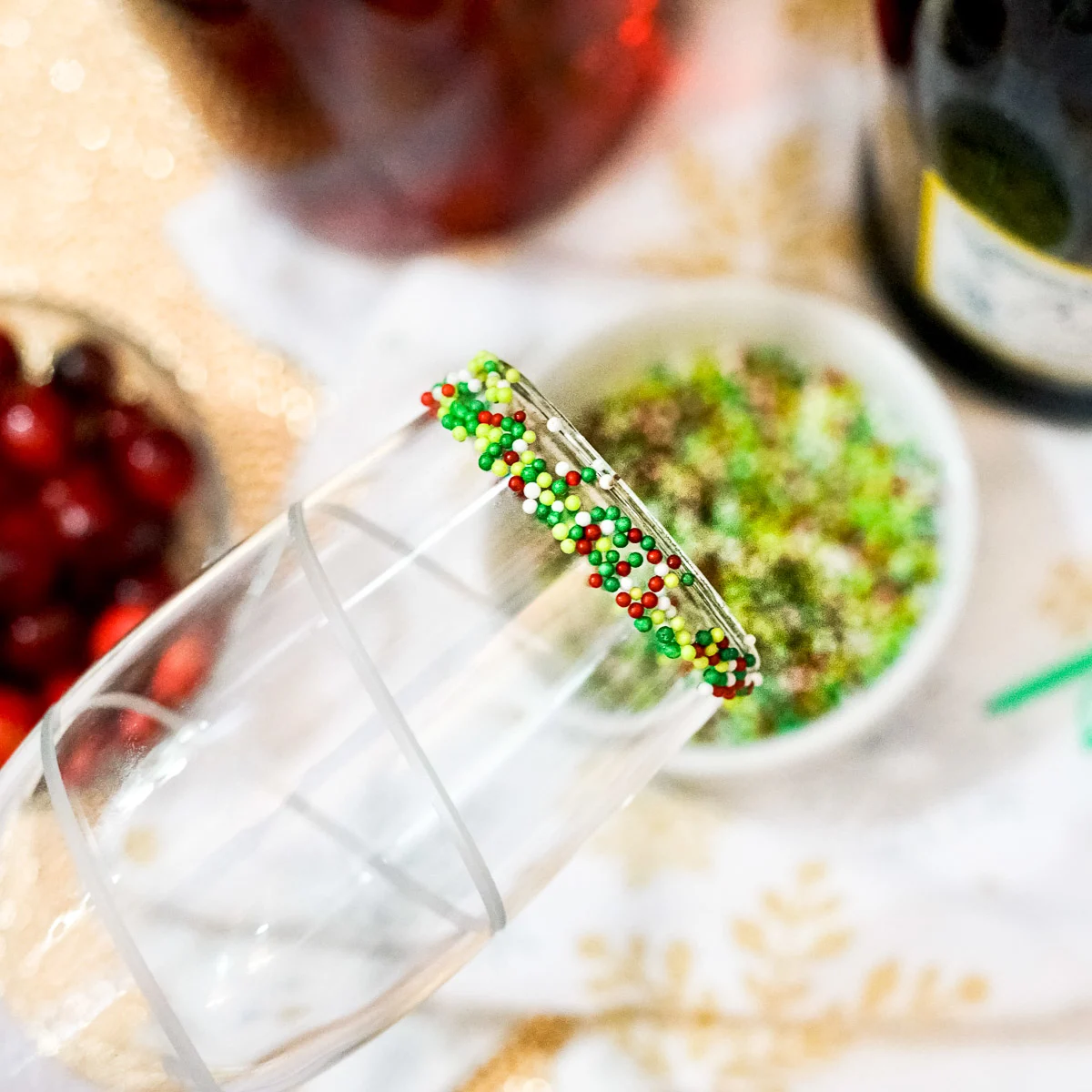 adding holiday sprinkles to a champagne glass