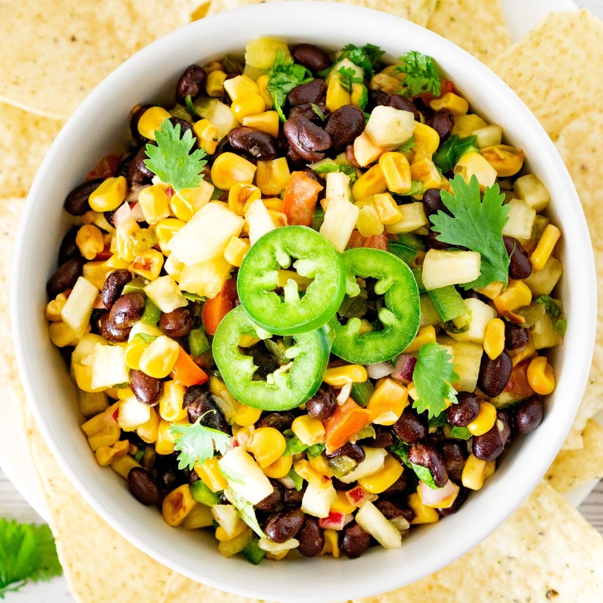 bowl of black bean pineapple salsa with chips on the side