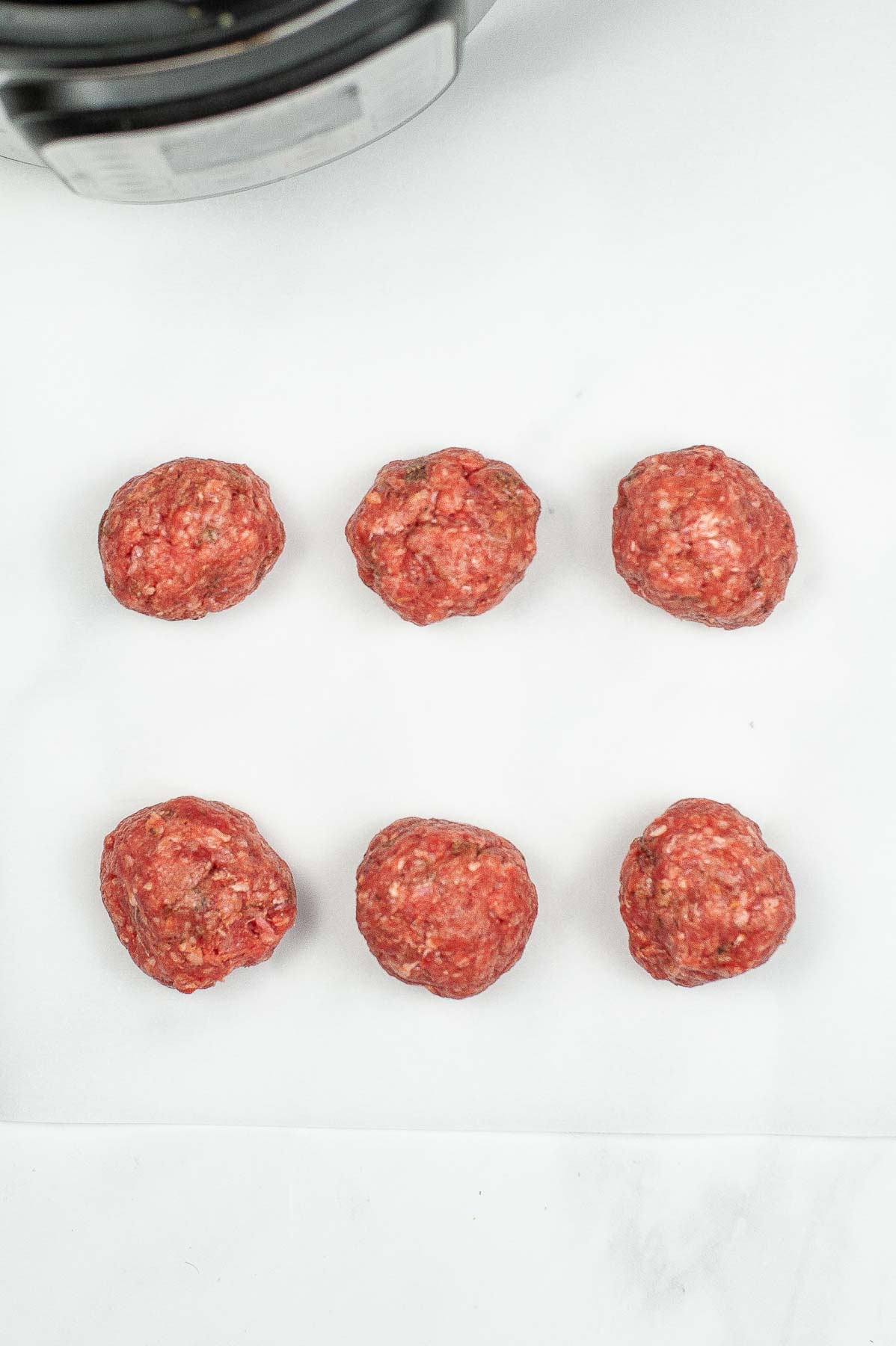 Seasoned ground beef divided into 6 balls.