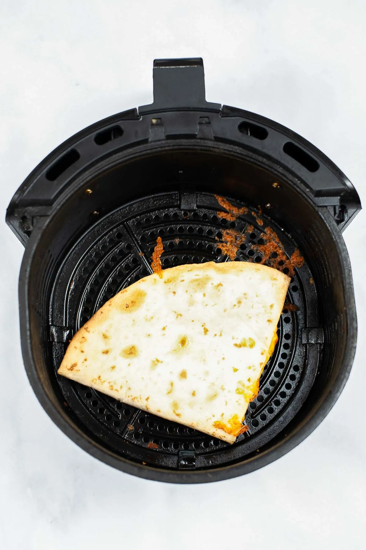 Cooked quesadilla in an air fryer.