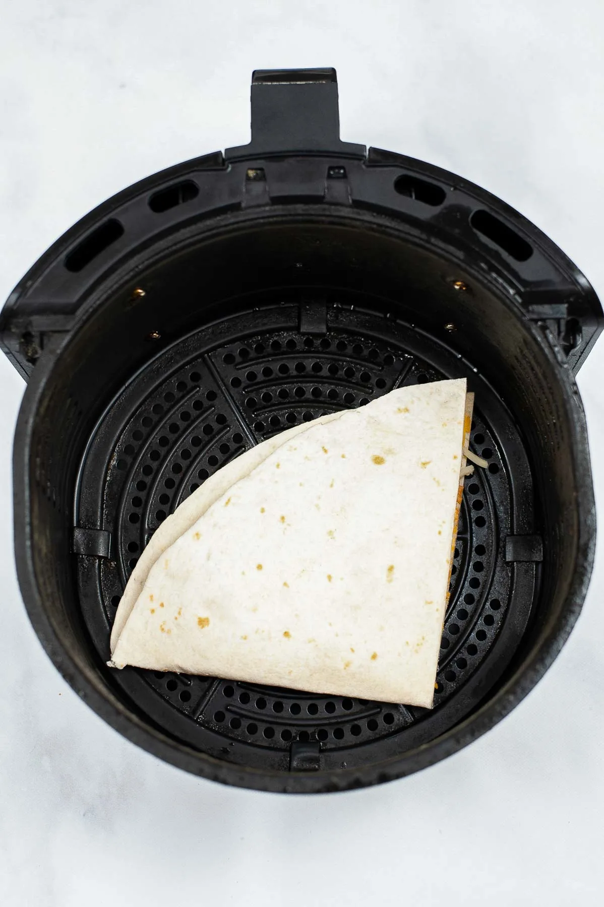 Making a quesadilla in an air fryer.