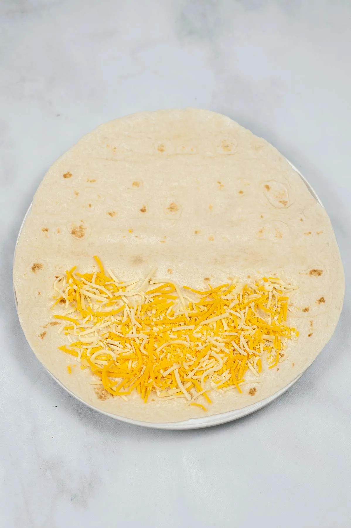 Cheese on a tortilla to make a quesadilla.