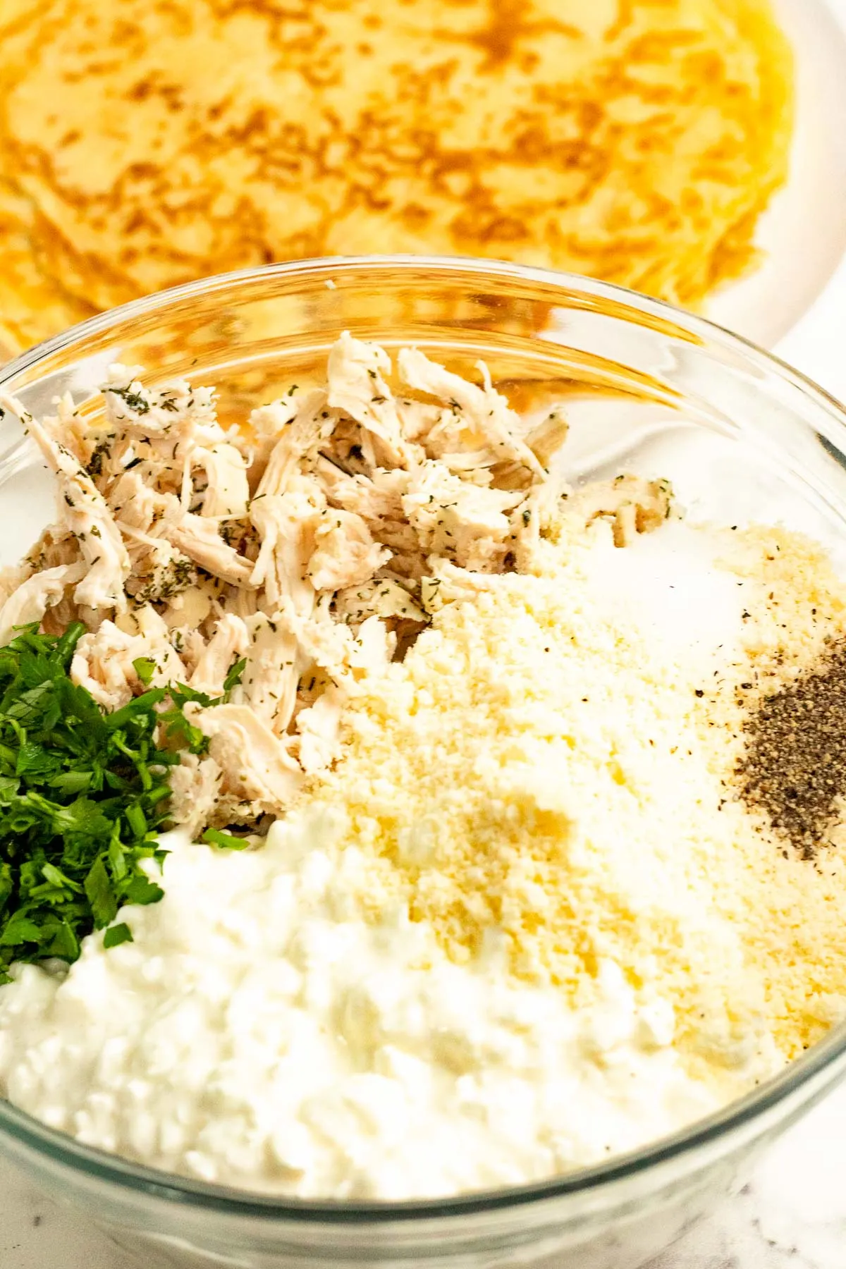 Savory chicken crepe filling ingredients in a bowl.