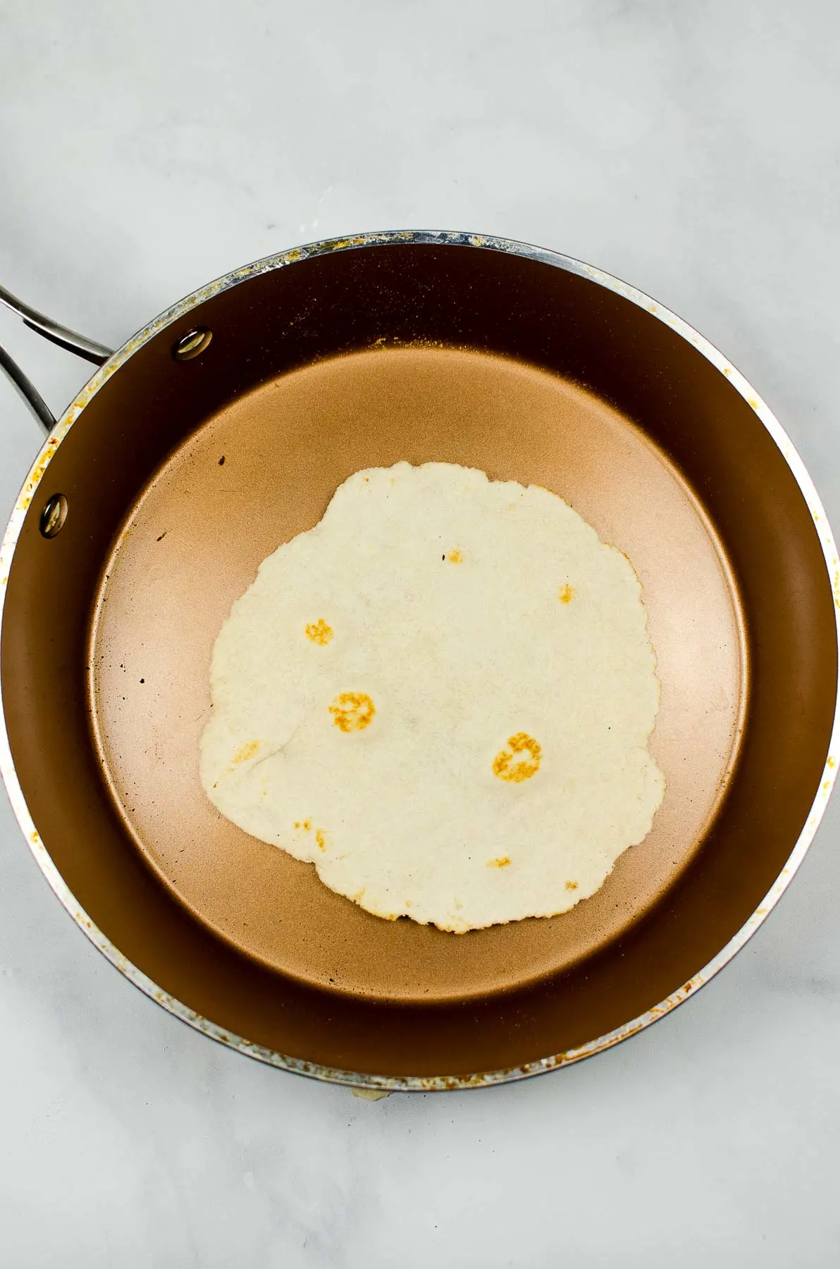 Cooking a homemade tortilla in a skillet.
