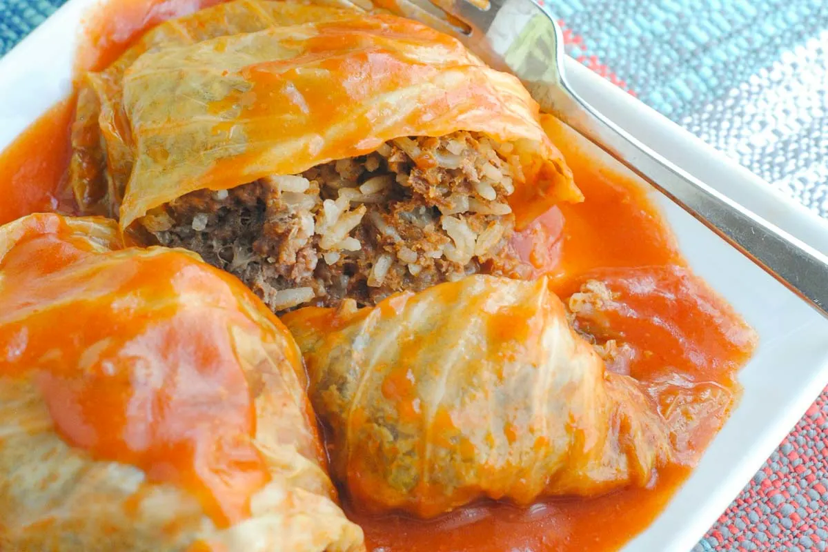 Russian Stuffed Cabbage Rolls on a plate with tomato sauce.