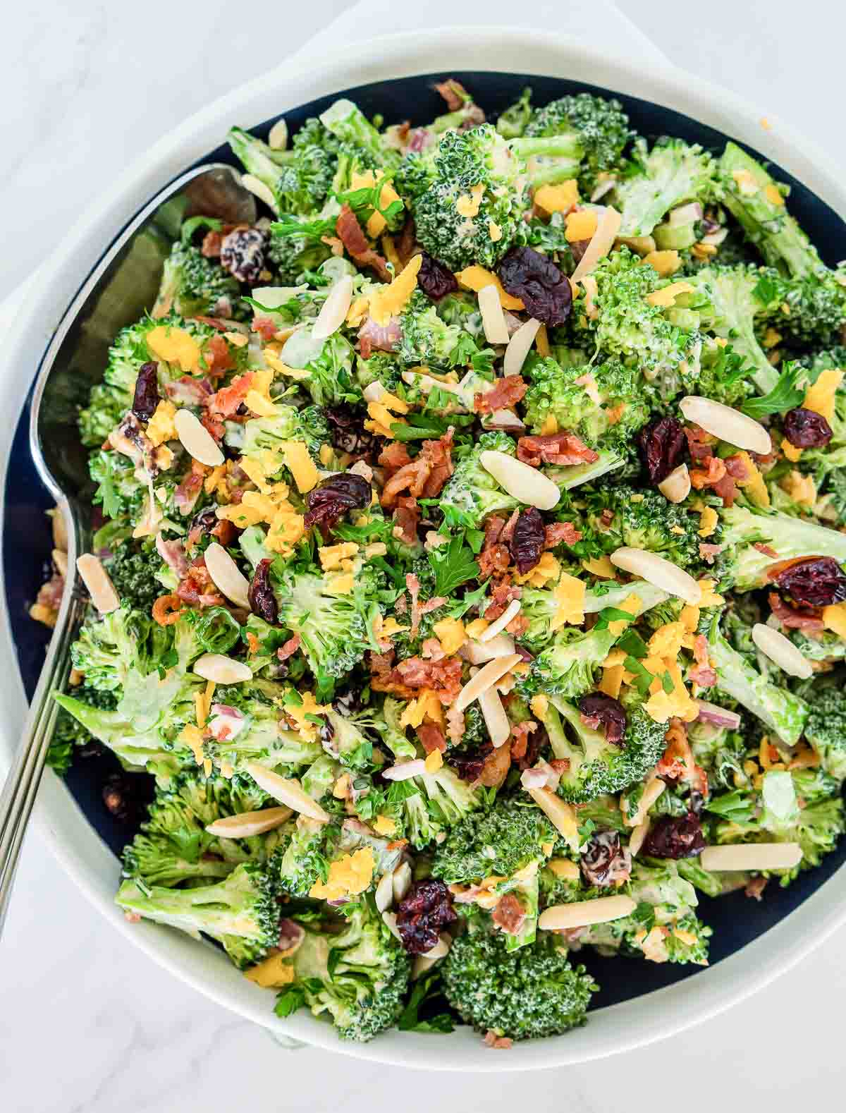 Bowl of broccoli salad with bacon, cheese, cranberries, and almonds.