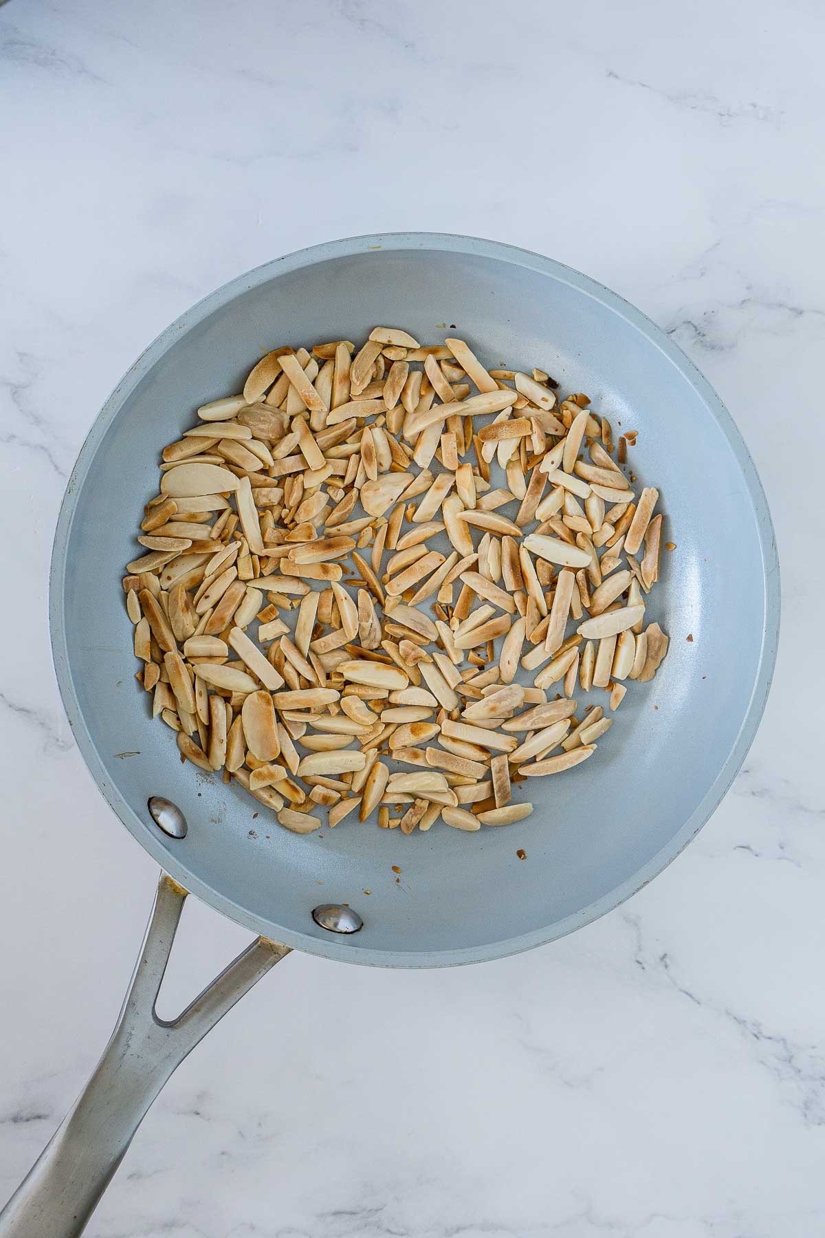 Toasted slivered almonds in a pan.