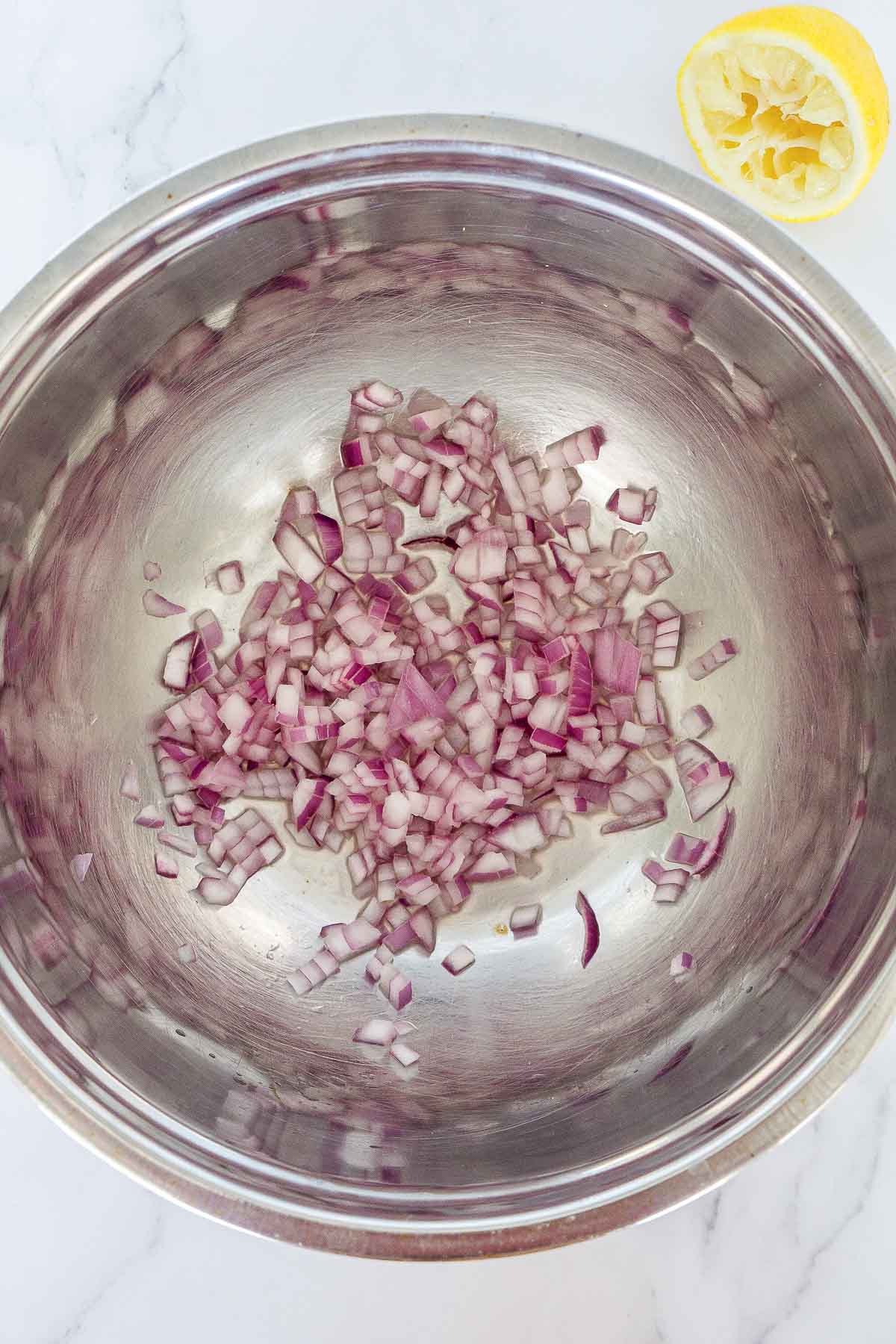 Red onion and lime juice in a bowl.