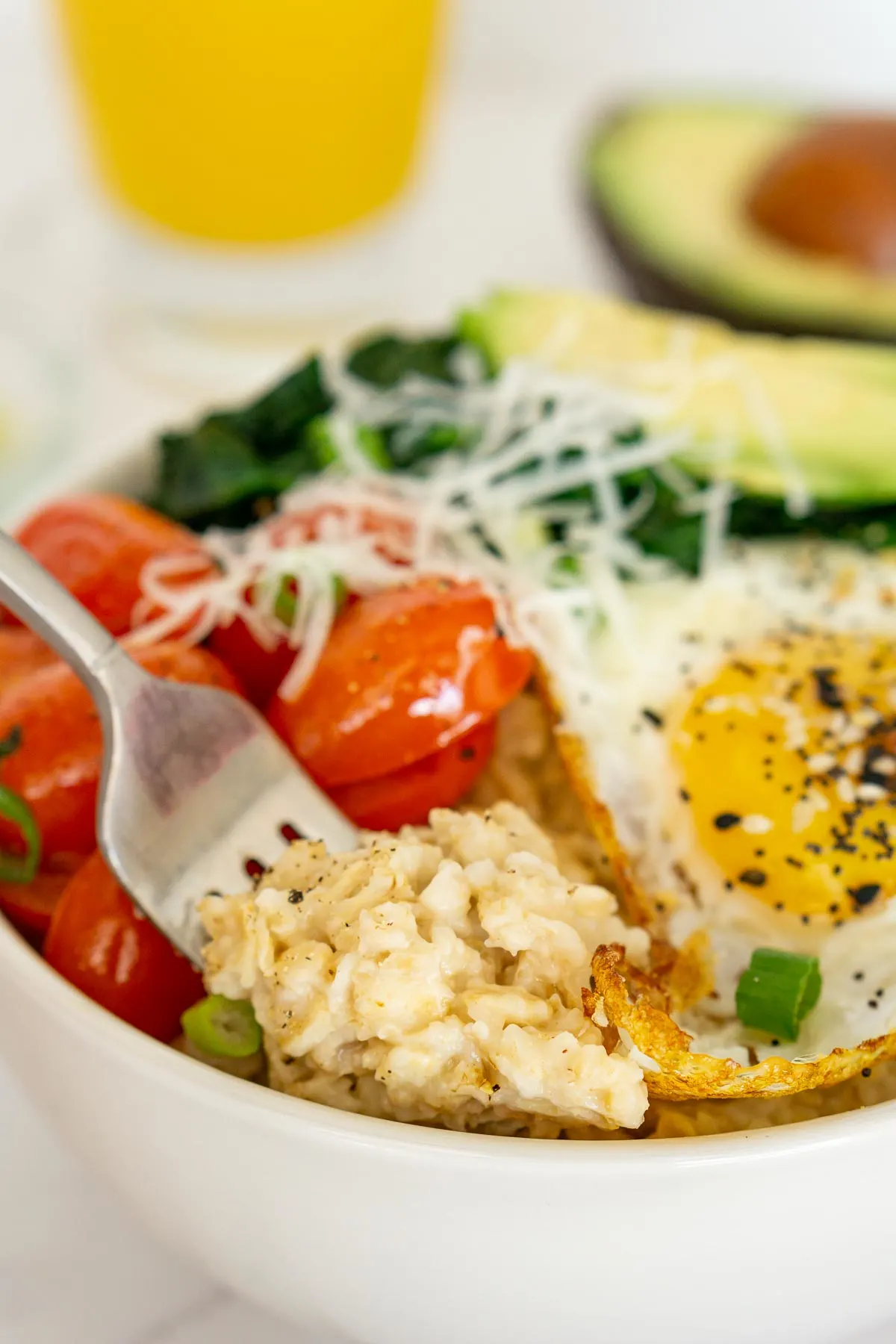 Savory oatmeal with eggs and veggies in a bowl.