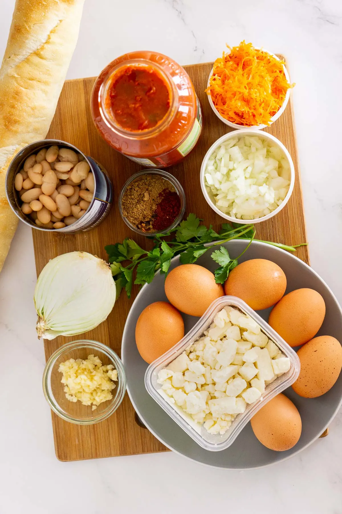 Ingredients to make shakshuka with feta and white beans.