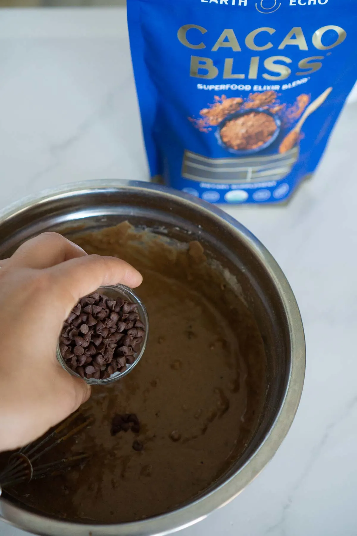 Adding chocolate chips to chocolate pancake batter.