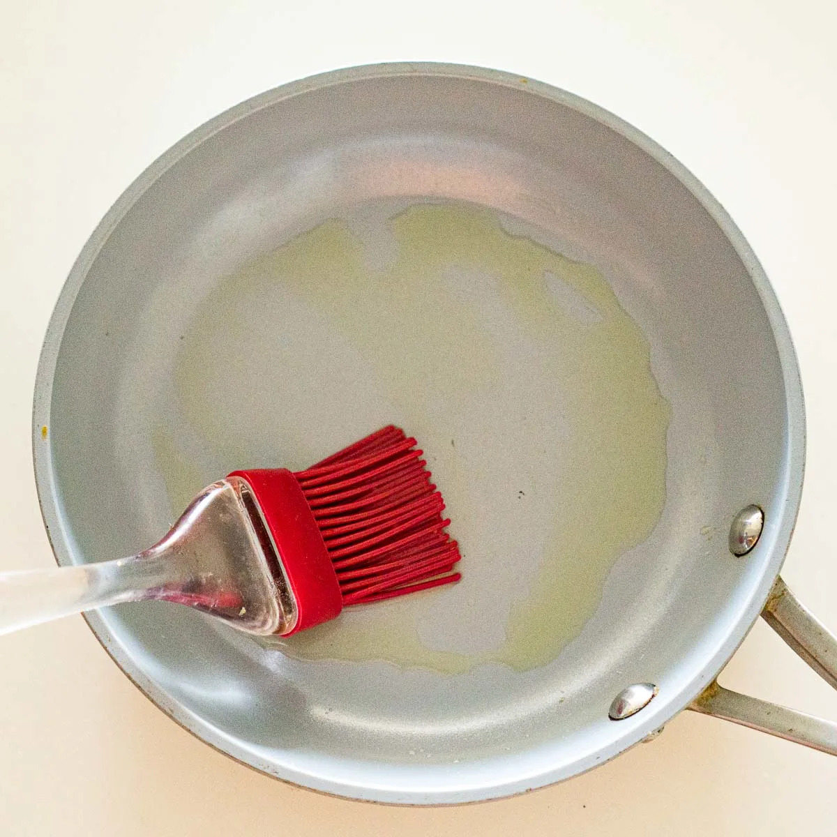 Brushing a non stick pan with oil.
