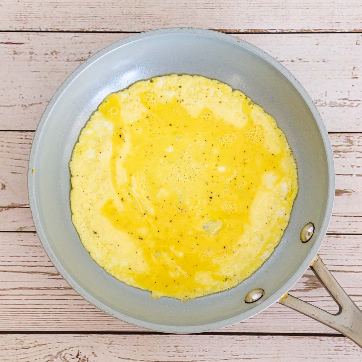 1 scrambled egg cooking in a pan.