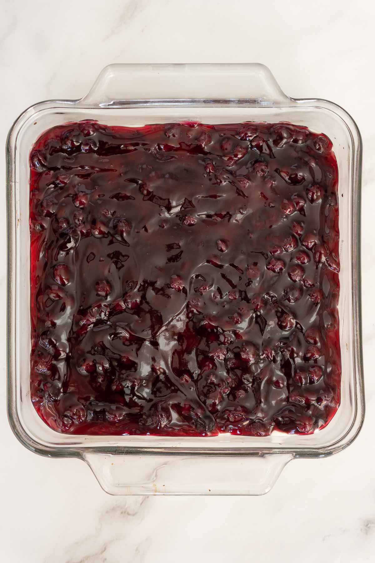 Layer of blueberry pie filling in a baking dish.