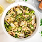 Bowl of grilled asparagus salad with white beans.