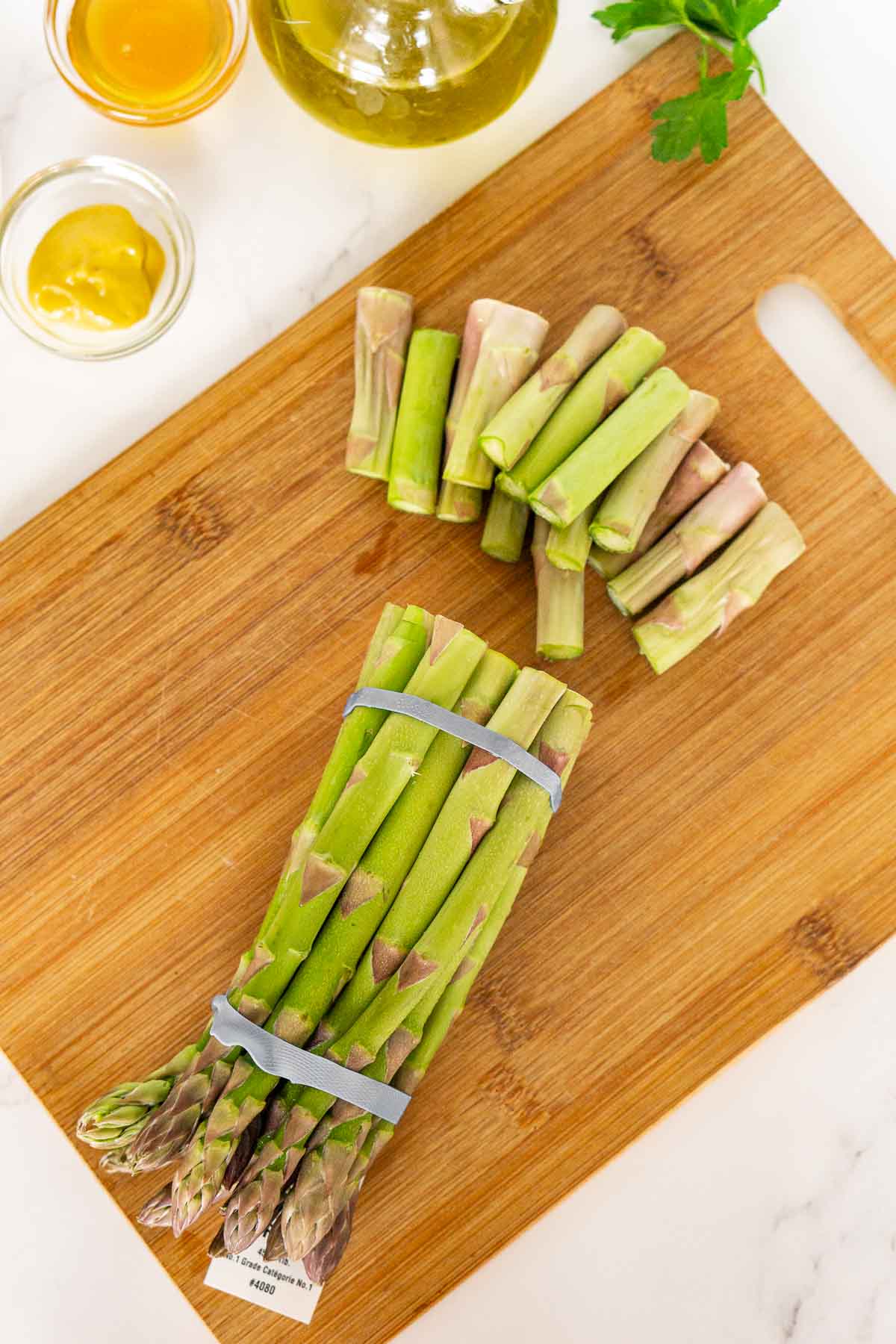 Asparagus on a cutting board with ends trimmed off.