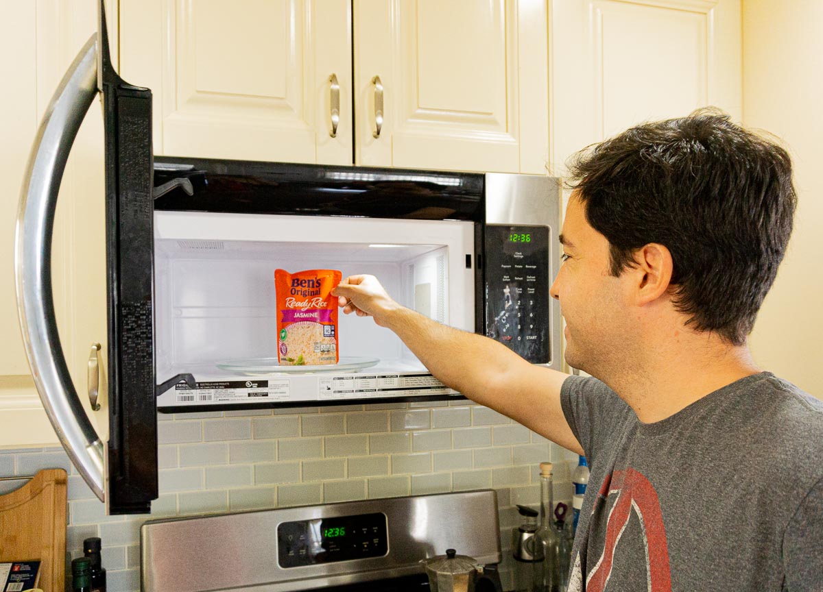 Man grabbing a pouch of Ben's Rice out of the microwave.