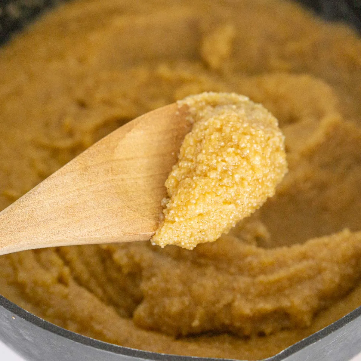 Cooked pumpkin cream of wheat on a spoon.