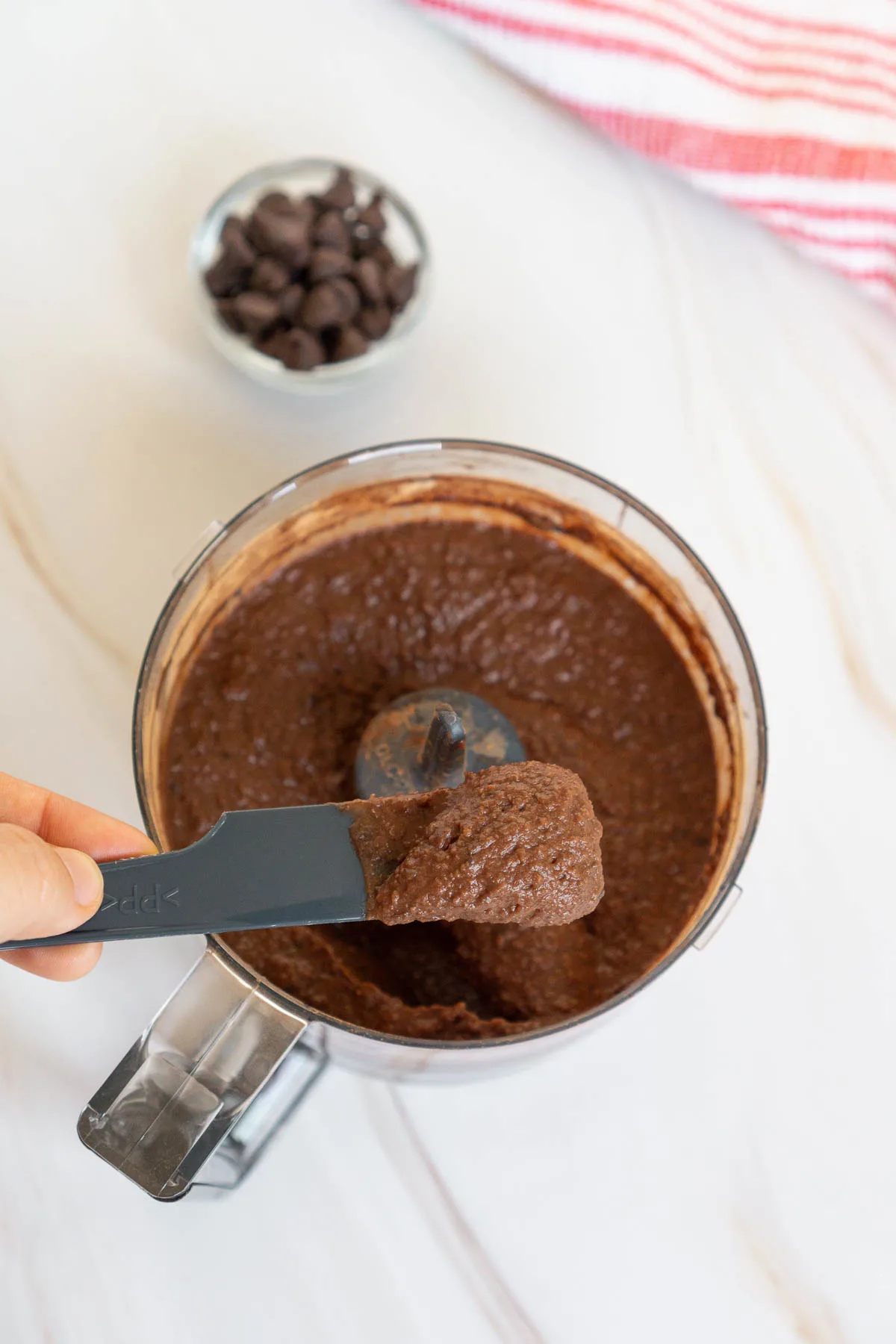 A small spatula showing the texture of chocolate hummus after blending.