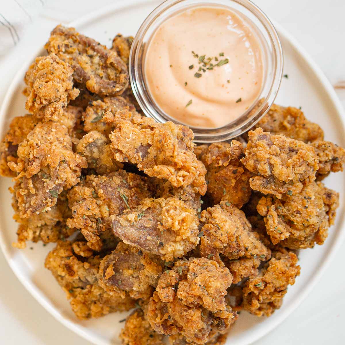 Overhead shot of popcorn fried chicken hearts with dipping sauce.