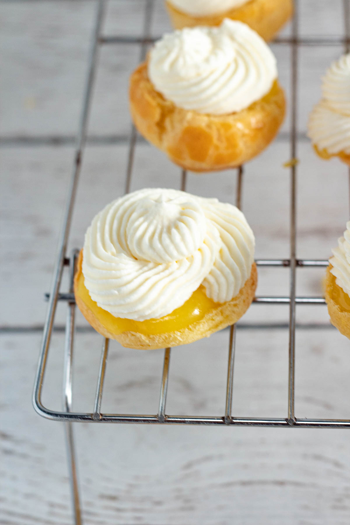 Lemon and cream cheese cream puff on a wire rack.