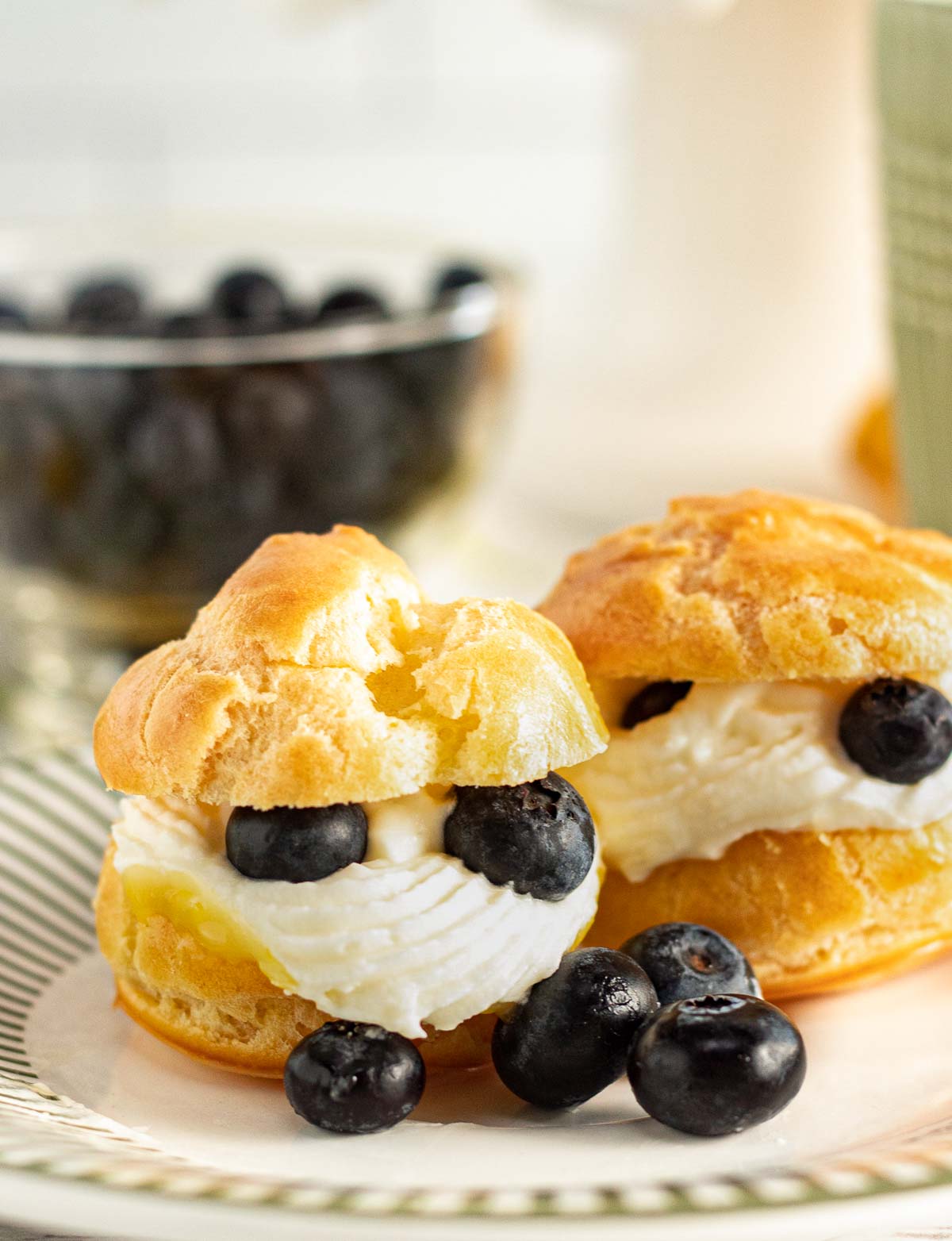 Cream puffs with lemon curd and cream cheese icing on a plate.