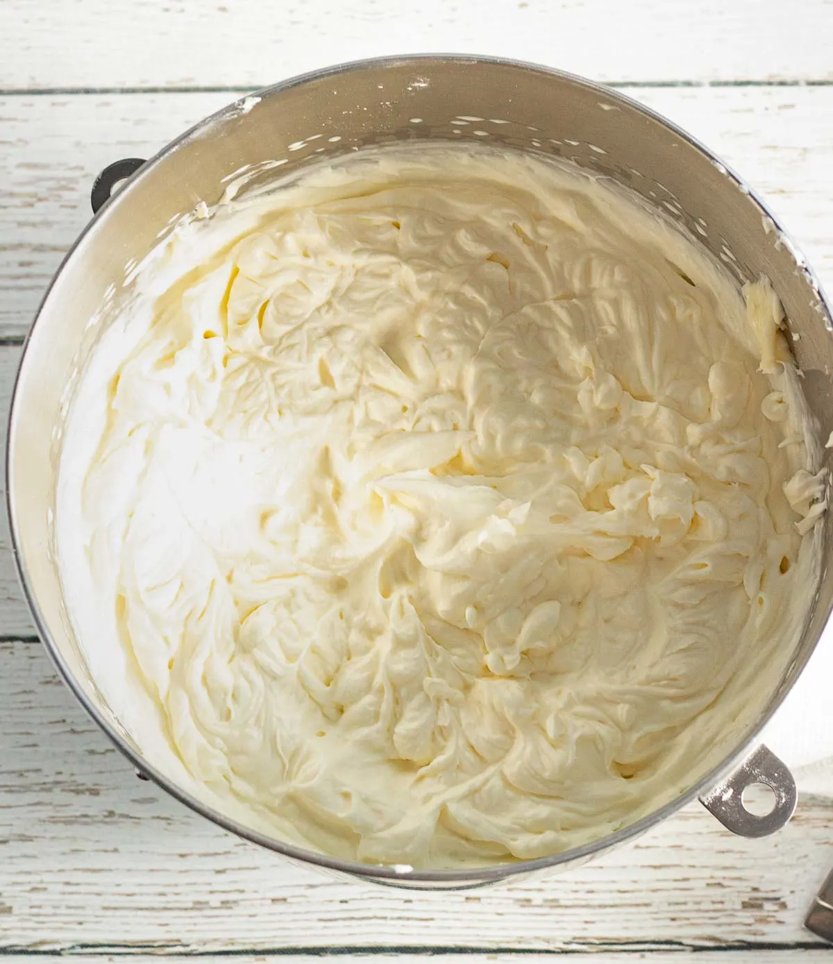 Making cream cheese icing in a bowl.