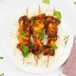 Plate of rice with tandoori chicken kebabs.