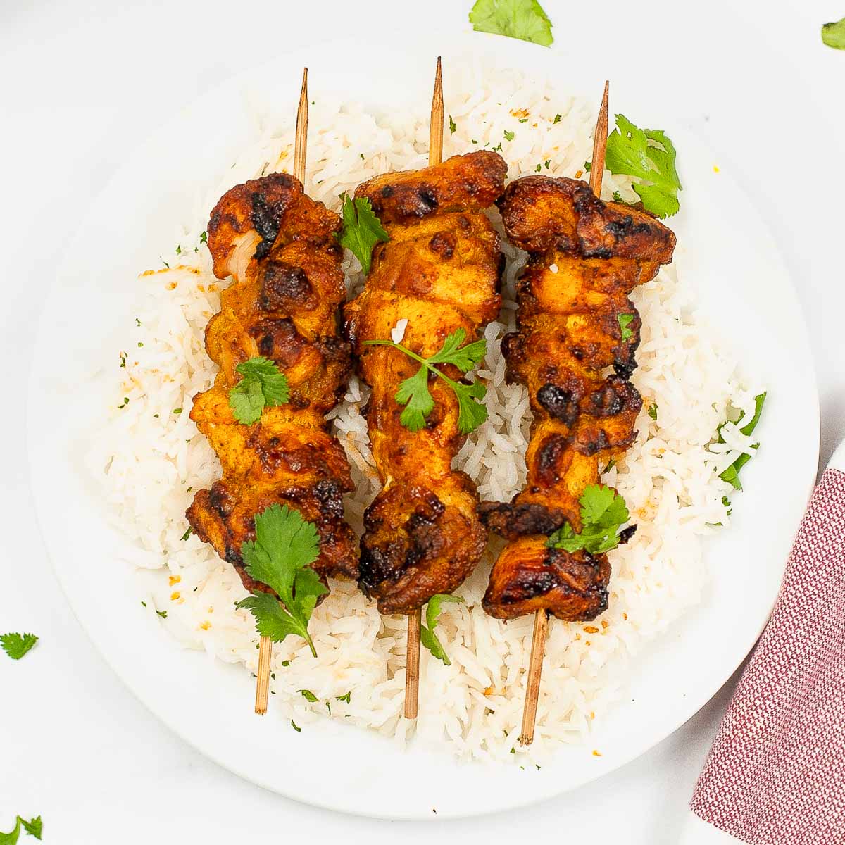 Plate of rice with tandoori chicken kebabs.