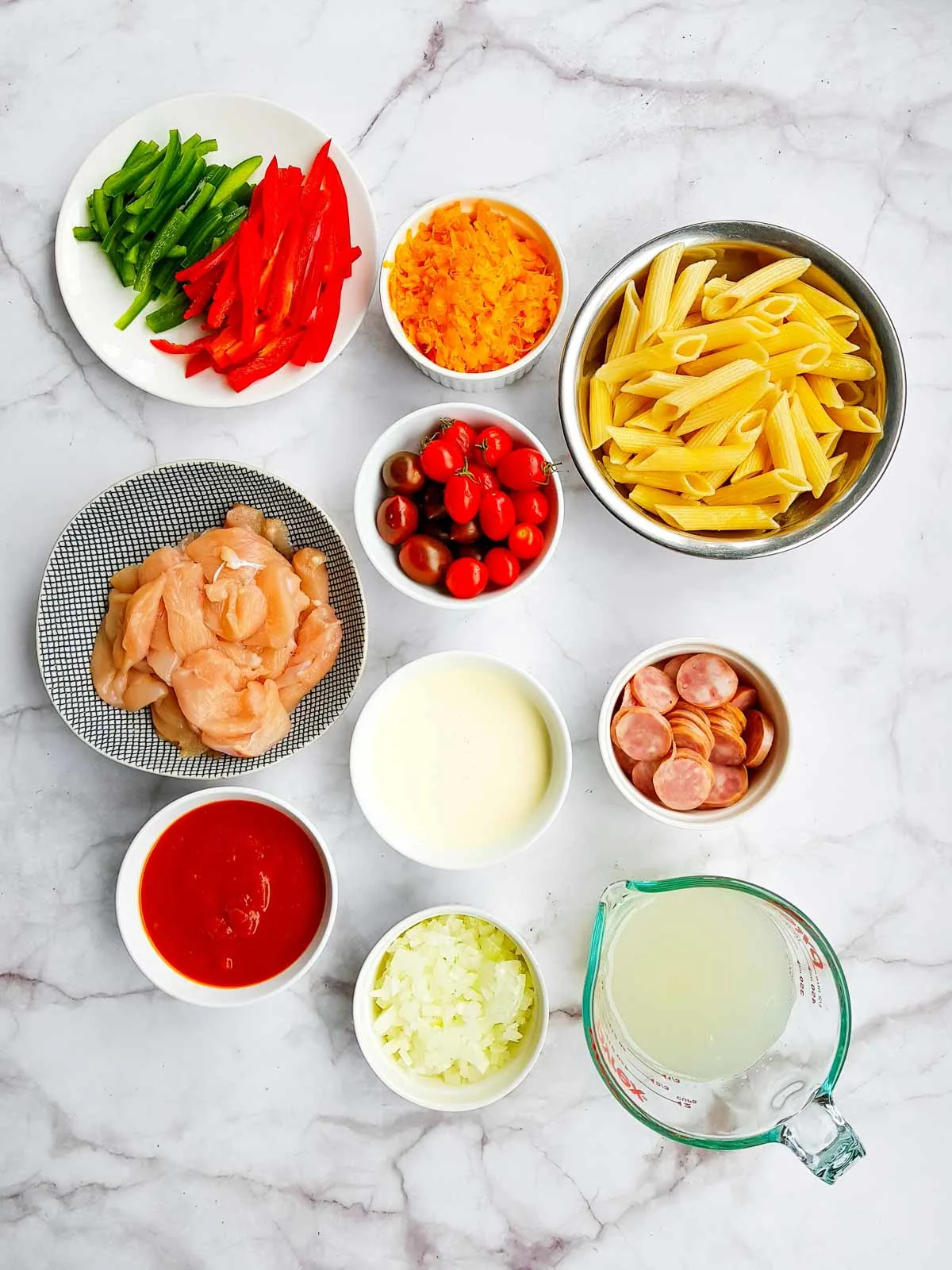 Ingredients to make Cajun chicken pasta with sausage.