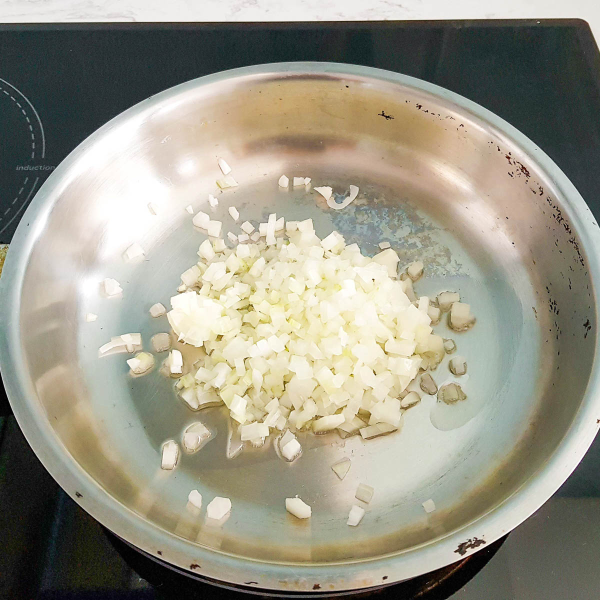 Sauteing diced onion in a pan.