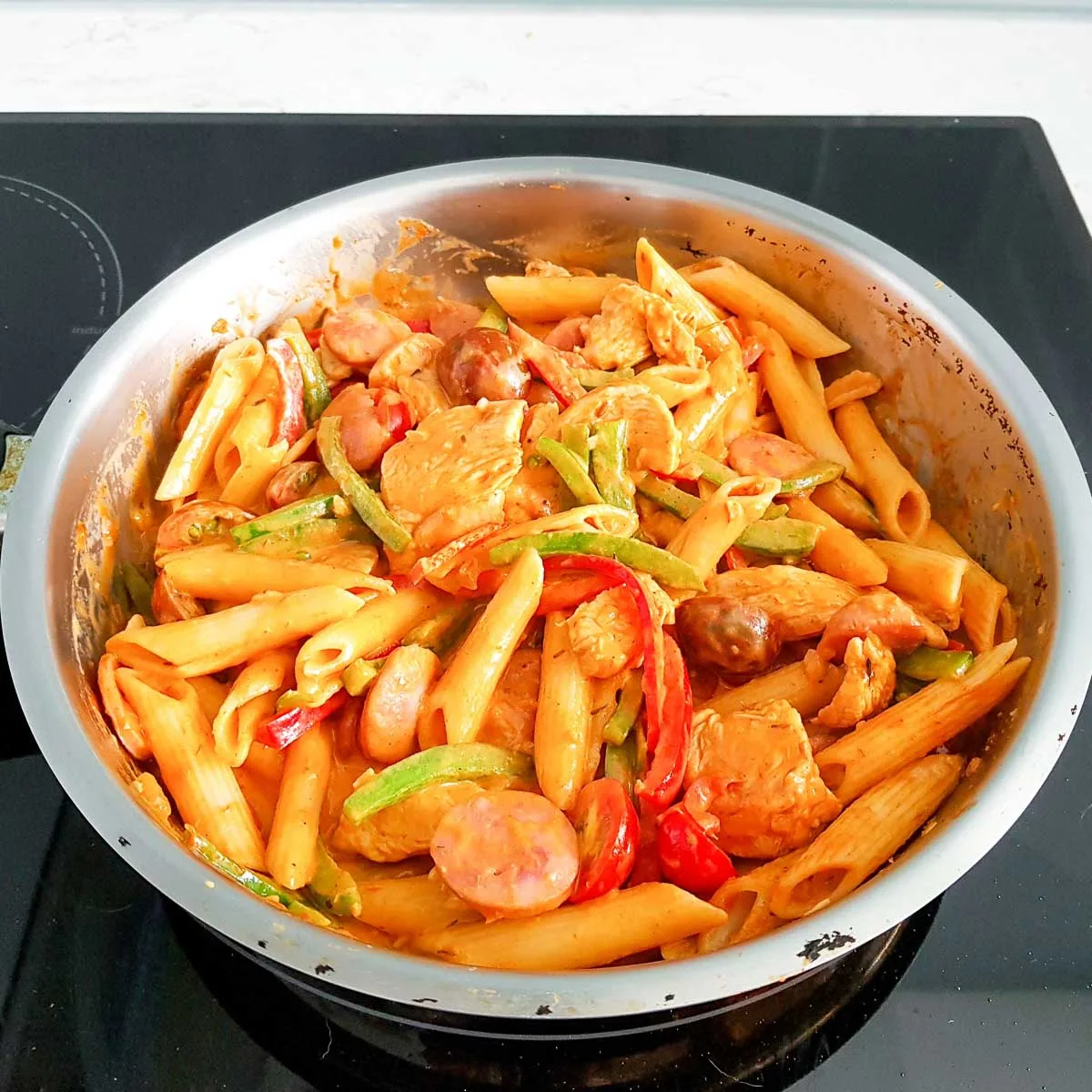 Creamy Cajun chicken pasta with peppers in a pan.