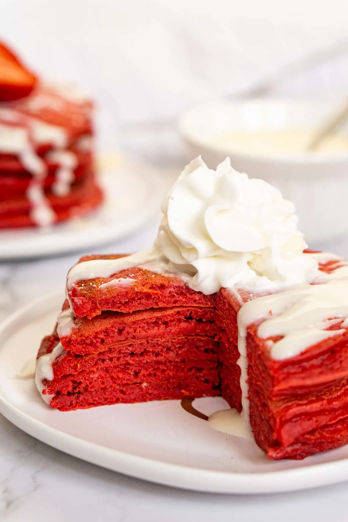 Red velvet pancakes with a slice cut out to show inside texture.