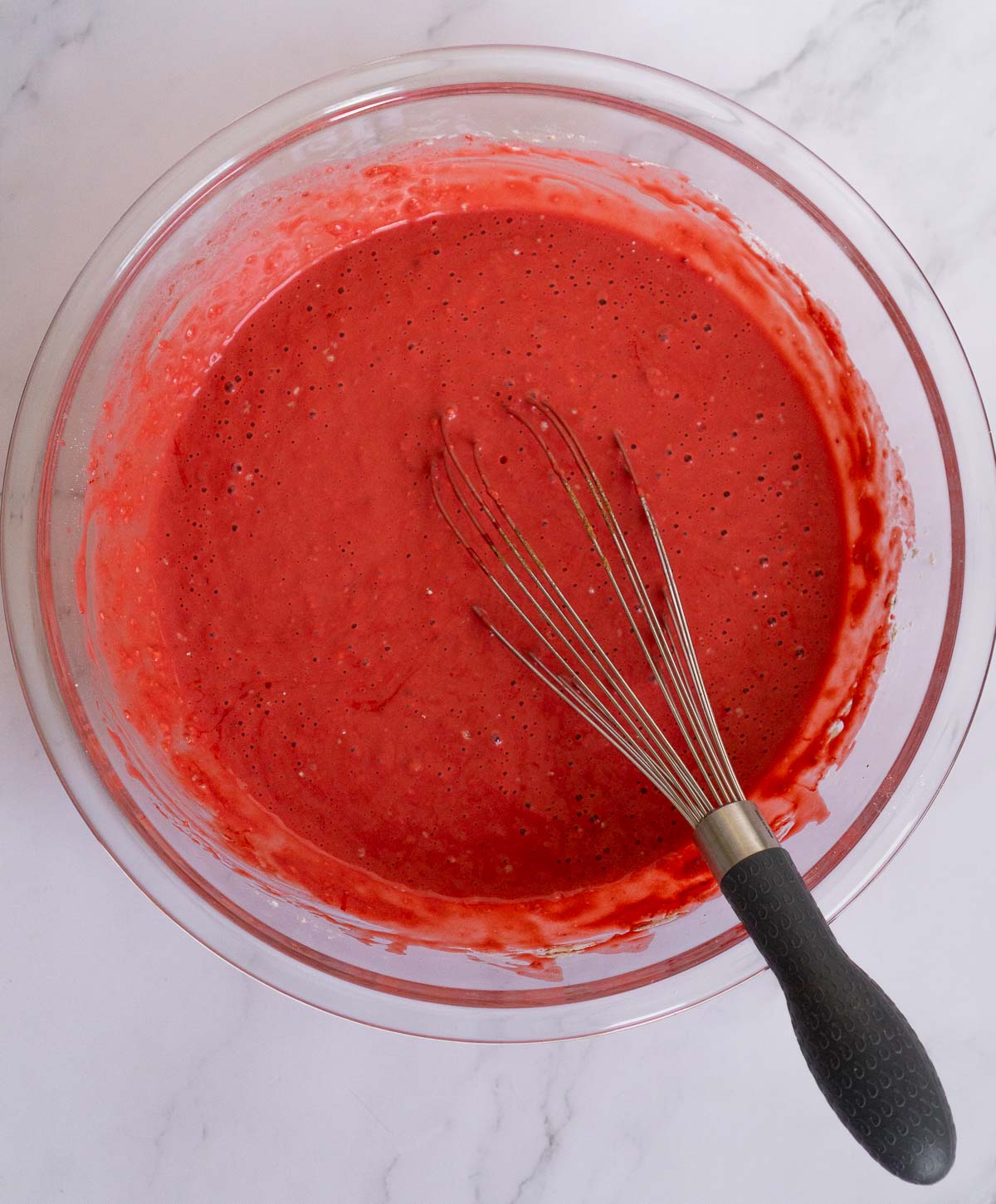 Batter for red velvet pancakes in a bowl.
