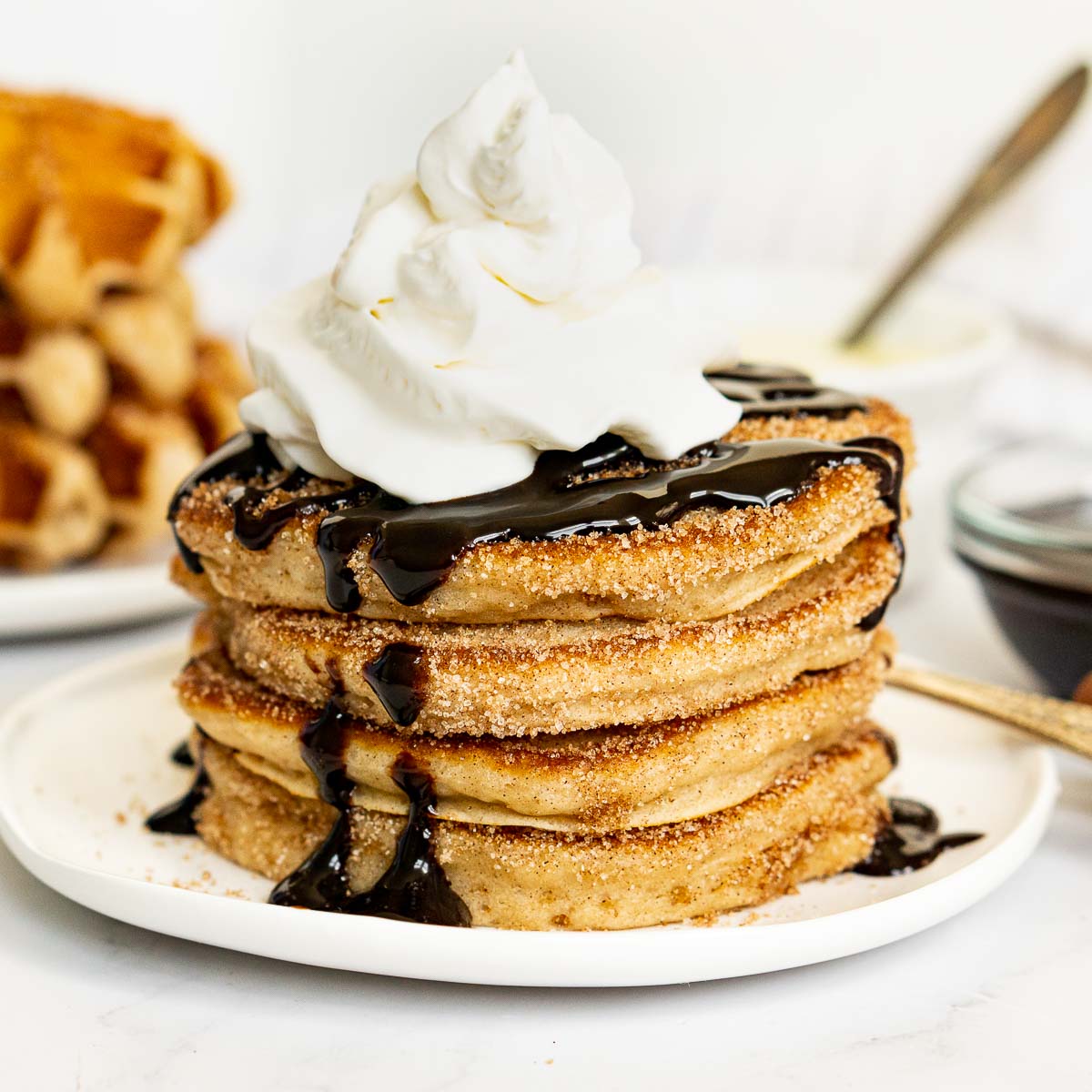Churro pancakes with chocolate sauce and whipped cream