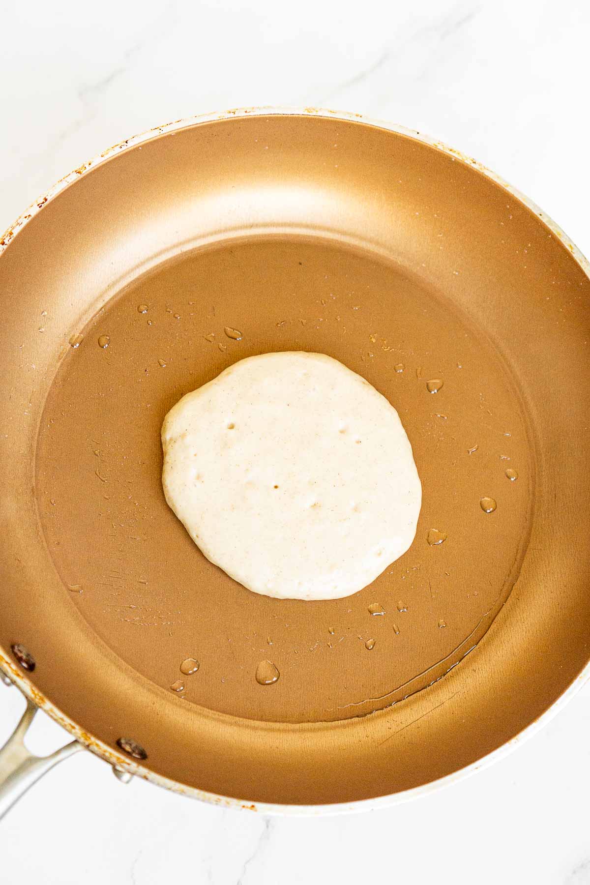 Cinnamon pancake cooking in a pan.