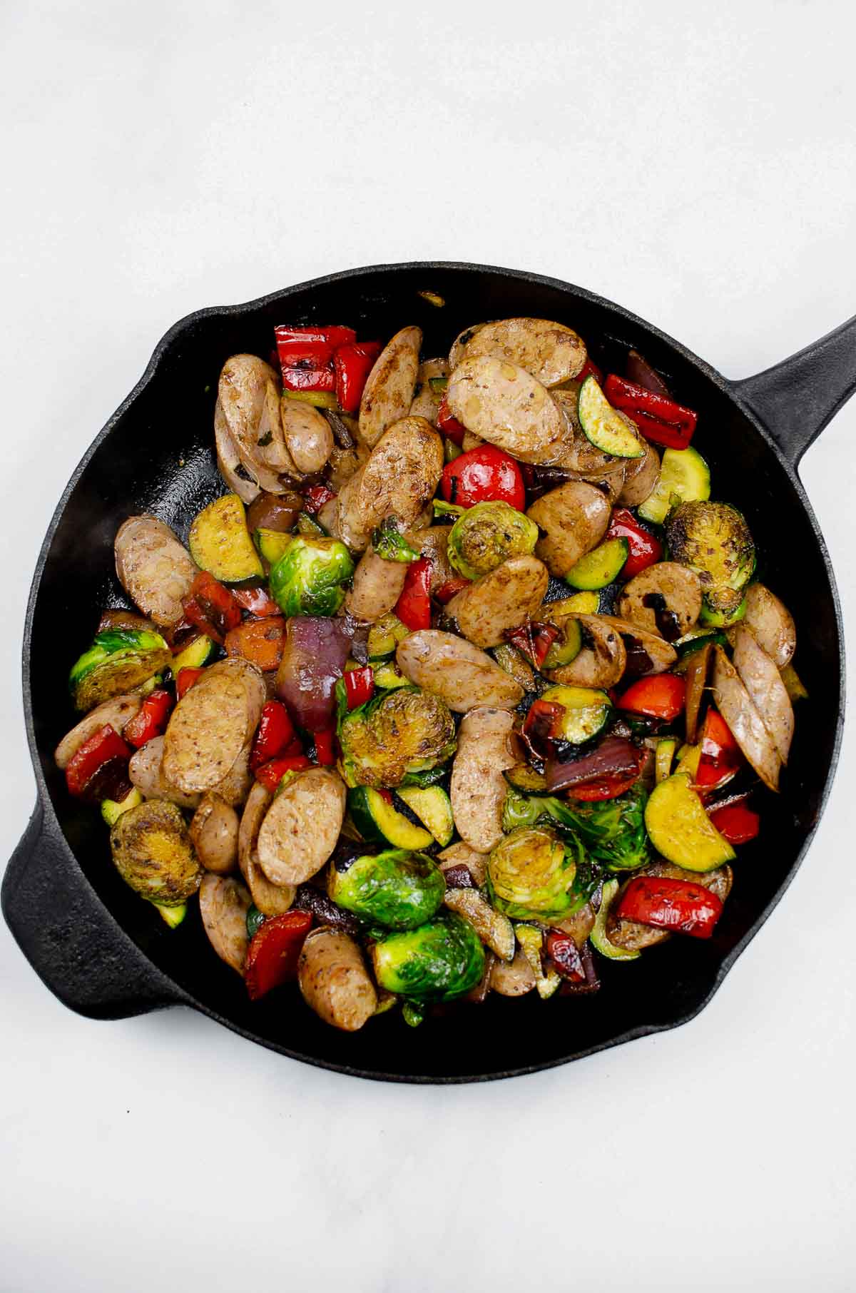Cast iron skillet with vegetables and chicken sausage stir fry