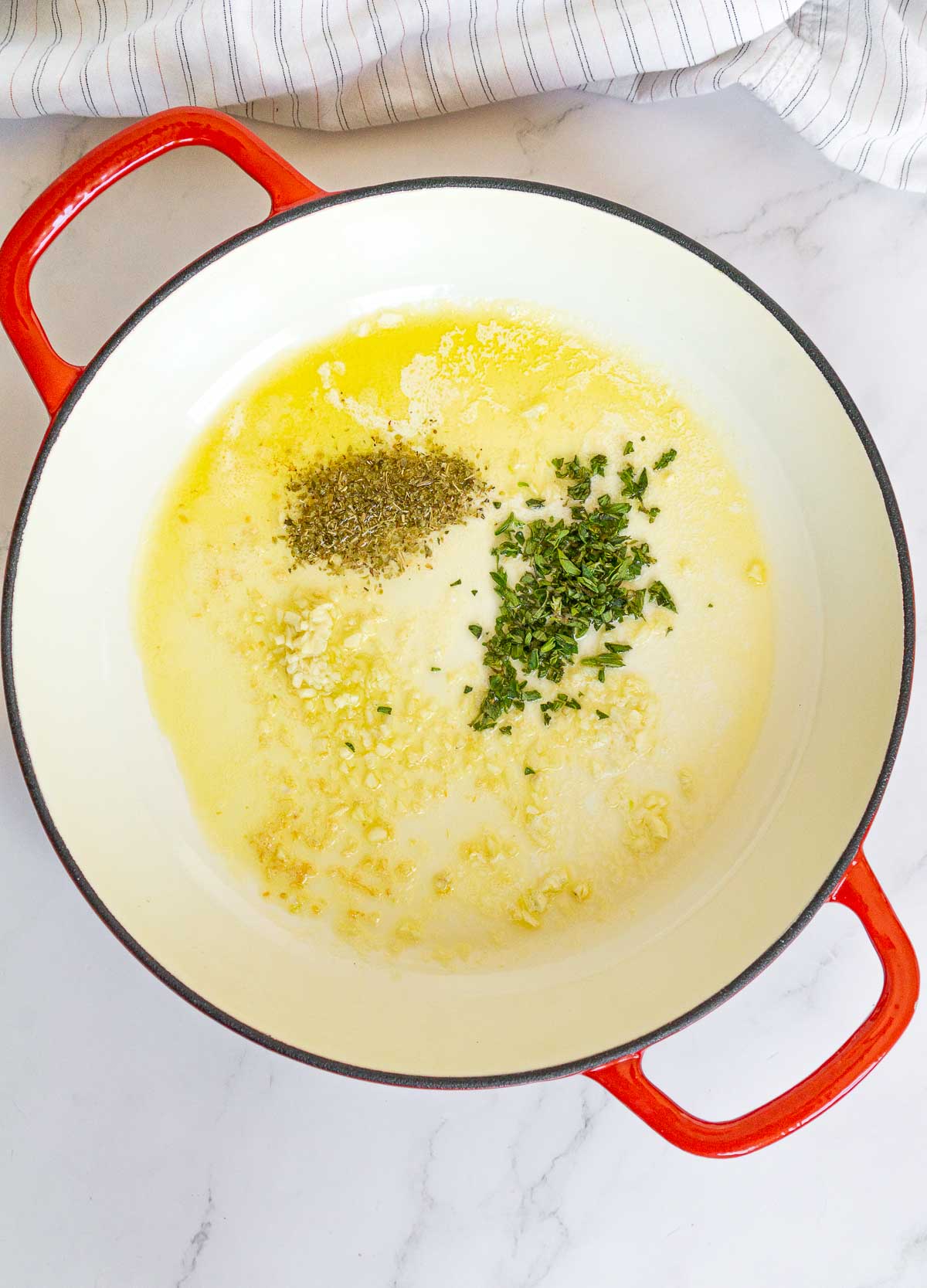 Fresh oregano and dried oregano in a pan with garlicky olive oil.