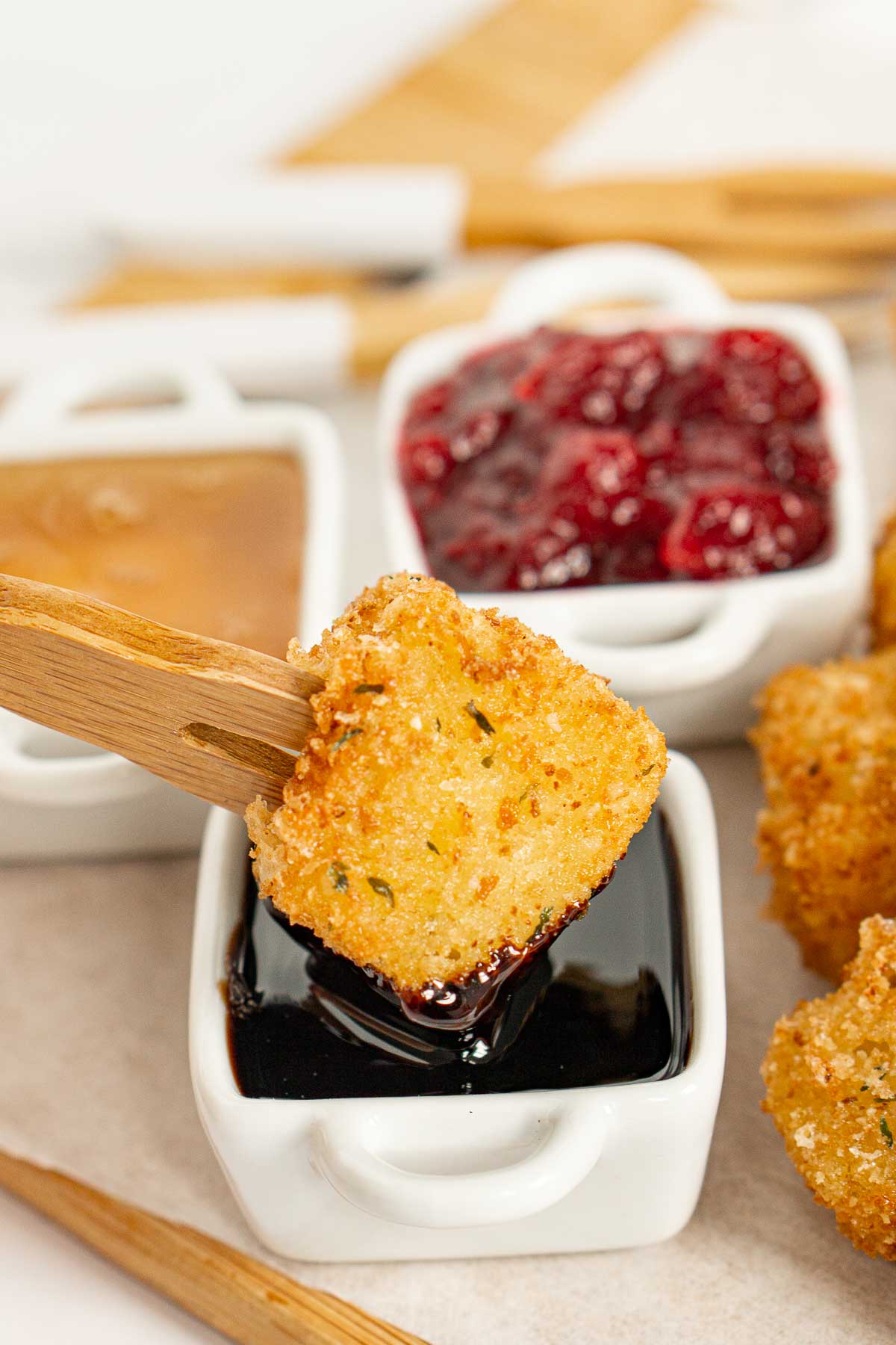 Dipping fried brie into balsamic glaze