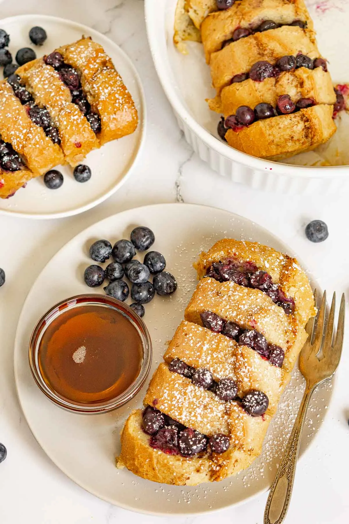 Hasselback French Toast on a plate with the baking pan near by