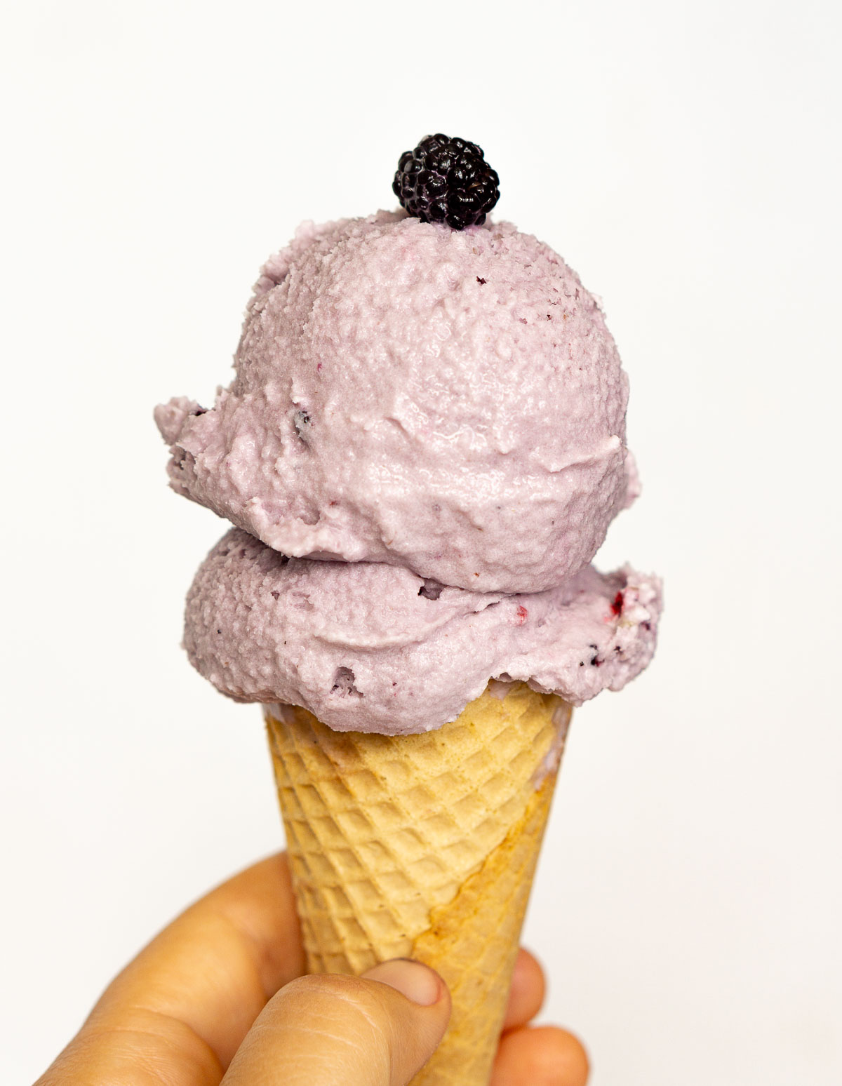 An ice cream cone with 2 scoops of mulberry ice cream