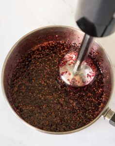 Using an immersion blender to puree the mulberry syrup