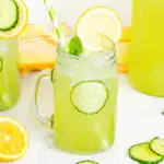Cucumber lemonade in a mason jar garnished with lemons and cucumbers
