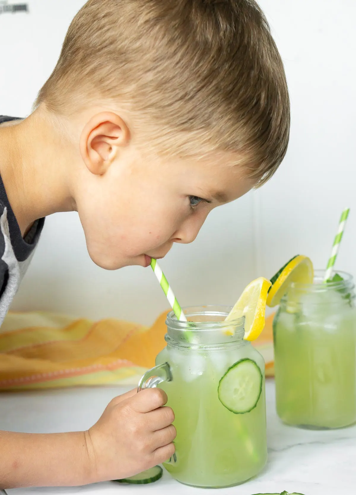 Child drinking cucumber lemonade