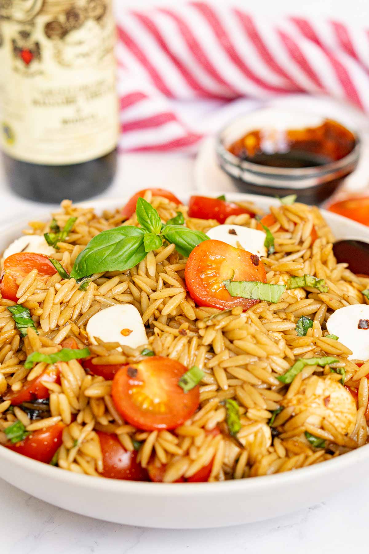 Orzo caprese salad with balsamic glaze in a bowl